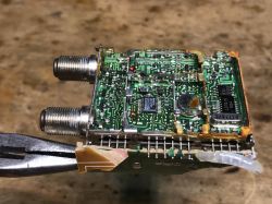 Płytka drukowana z tunerem satelitarnym i komponentami elektronicznymi.