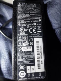 Zbliżenie na etykietę zasilacza Delta Electronics z różnymi oznaczeniami technicznymi.