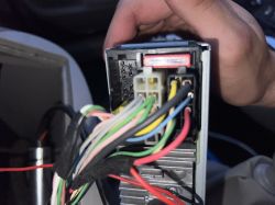 Tył radia samochodowego Philips 22D239/62 z wiązką przewodów podłączoną do złącza.