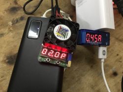 BY-K7 power bank under load with USB voltage and current testers attached