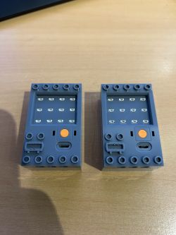 LED-Controller für Lego mit USB-C-Anschlüssen Zwei graue LED-Controller für Lego mit USB-C-Anschlüssen auf einem Holztisch.