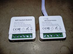 WiFi Switch Modules MINI-W1-2CH and MINI-W1-3CH Two WiFi switch modules MINI-W1-2CH and MINI-W1-3CH lying on a surface.