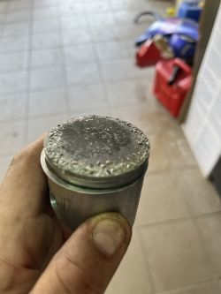 Widok uszkodzonego tłoka z uszkodzeniami na powierzchni.