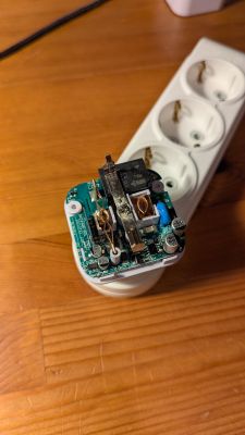 Disassembled smart plug showing relay and internal circuit board components.