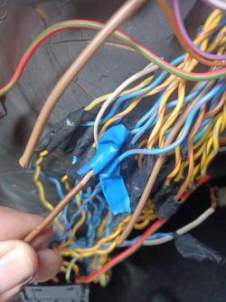 Zbliżenie na wiązkę przewodów elektrycznych z widoczną izolacją i niektórymi przewodami odsłoniętymi