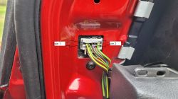 Konektor elektryczny w prawych drzwiach samochodu z oznaczonymi pinami 1 i 2.