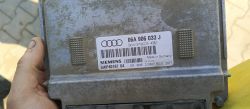 Sterownik ECU Audi Siemens o numerze 06A 906 033 J trzymany w brudnej dłoni.