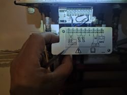 Image of a hand holding a panel with a wiring diagram in a furnace, showing entry numbers from 36 to 44.