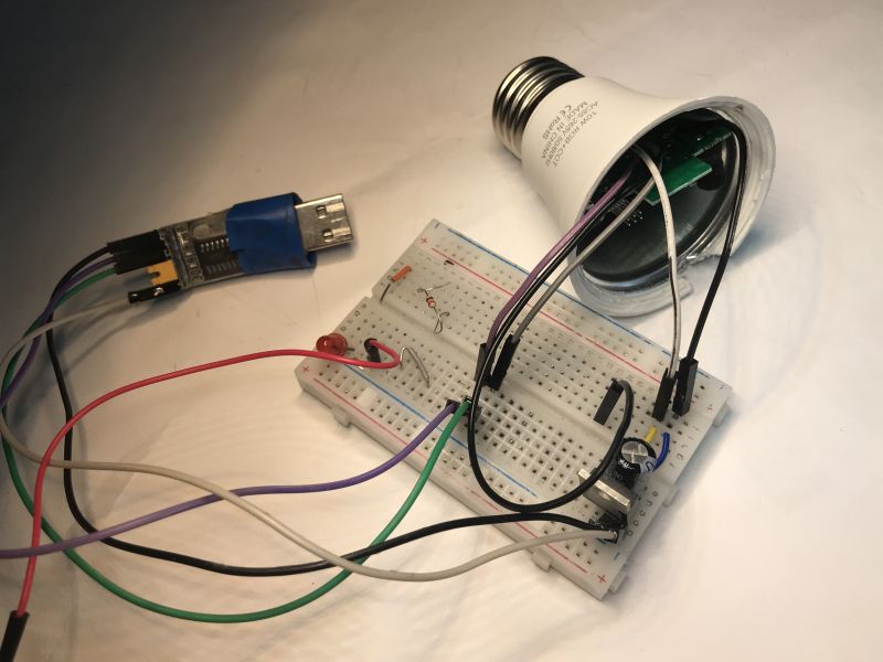 Dismantled TNCE Smart E27 LED Bulb with Breadboard Connection Dismantled TNCE Smart E27 LED bulb with a breadboard and USB to UART adapter.