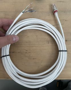 Kabel ethernet z wtyczką RJ-45 i odsłoniętymi przewodami po drugiej stronie.