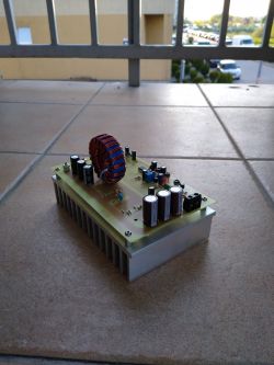 Power converter with a large coil and capacitors on a PCB.
