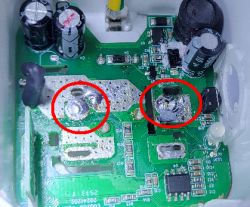 Damaged circuit board with burnt components marked by red circles