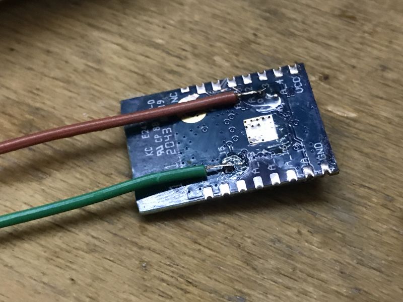 WBR3 module with two soldered wires on a wooden surface.