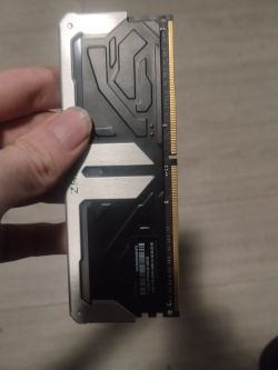 Kość RAM DDR4 trzymana w ręce, widoczna nierówność na radiatorze