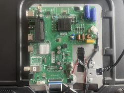 Zdjęcie zielonej płytki drukowanej z różnymi komponentami elektronicznymi i kablami.
