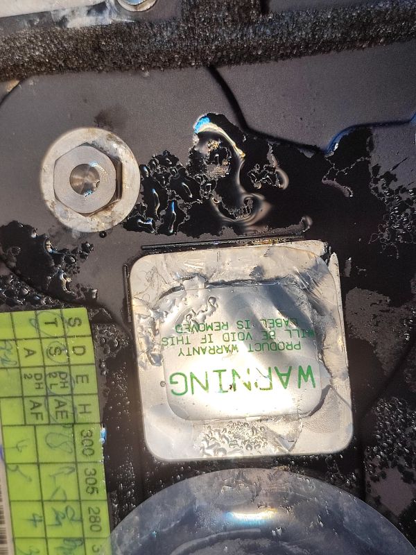Flooded Hard Drive with Warning Label Flooded hard drive with visible droplets of water and a warning label.