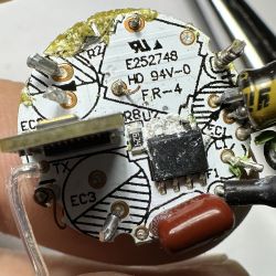 Close-up of the inside of a dismantled LED bulb showing the electronic board and components.