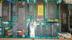 Zdjęcie zbliżenia na płytę główną z widocznymi układami scalonymi i elementami elektronicznymi.