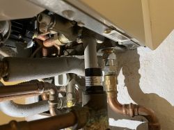 Close-up of plumbing installation under Junkers ZSR 18-5 KE boiler.