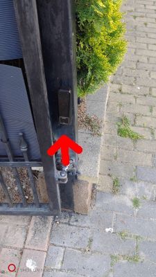 Czujnik zamontowany na słupku bramy, wskazany czerwoną strzałką.