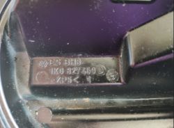 Zbliżenie na element samochodowy z numerem części i logo VW.