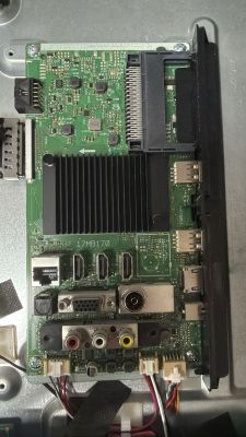 TV mainboard with heatsink and ports: HDMI, VGA, antenna, USB, and RCA connectors