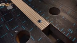 Board with Insert on Workbench Plywood board with threaded insert on a workbench.