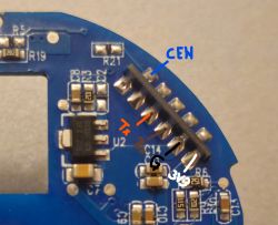 Close-up of blue PCB with labeled pins and SMD components