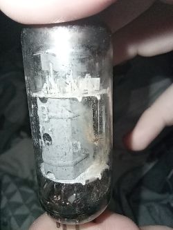 Lampa elektronowa trzymana w dłoni, z widocznymi metalowymi elementami wewnątrz bańki szklanej