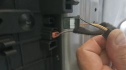 Zbliżenie niezidentyfikowanej kostki elektrycznej pod podsufitką pojazdu.