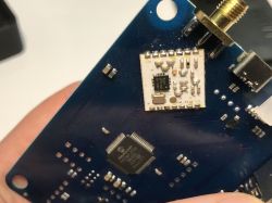 Close-up of a blue printed circuit board with integrated circuits and an electronic module.