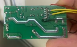Green PCB with several colored wires soldered at one edge