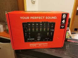 Czerwone pudełko interfejsu audio M-Audio AIR 192|14 na blacie kuchennym.