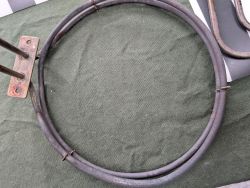 Okrągła grzałka metalowa z oznakami zużycia na zielonym materiale
