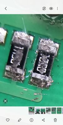 Zbliżenie na dwa rezystory na zielonej płytce drukowanej.