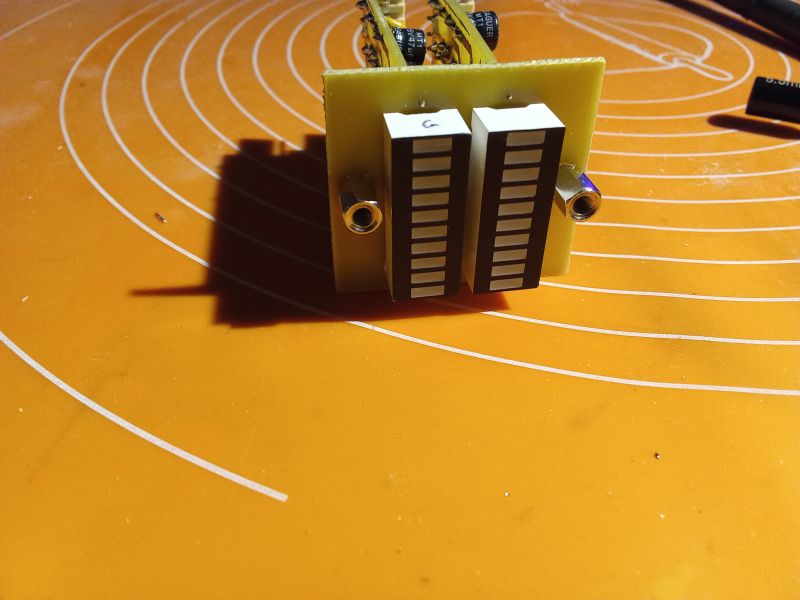 Two segment LED displays on a circuit board on an orange background.