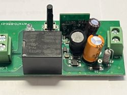 Close-up view of a circuit board with electronic components such as a relay, capacitors, and connectors.