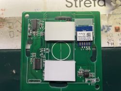Green PCB with a CB2S communication module and electronic components on a background with notes.