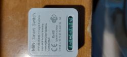 Mini smart switch with technical description on the casing.