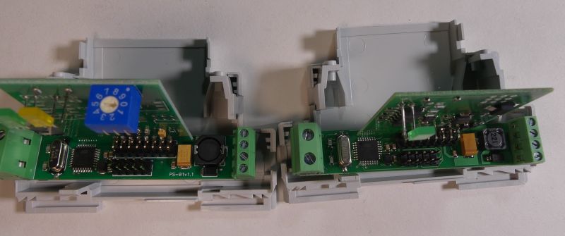 Dwa moduły elektroniczne w plastikowych obudowach, z widocznymi płytkami drukowanymi i elementami elektronicznymi.