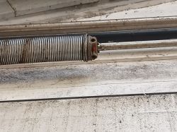 Przemysłowa sprężyna w mechanizmie bramy segmentowej.