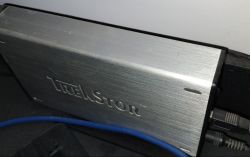 Metalowa obudowa z logo TrekStor z podłączonymi kablami.