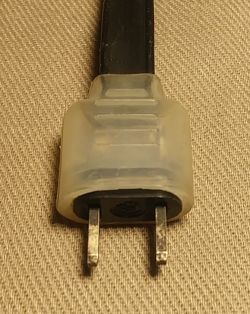 Two-prong electrical plug on textile material.