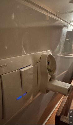 Wtyczka podłączona do gniazdka elektrycznego, oświetlona delikatnym niebieskim światłem.