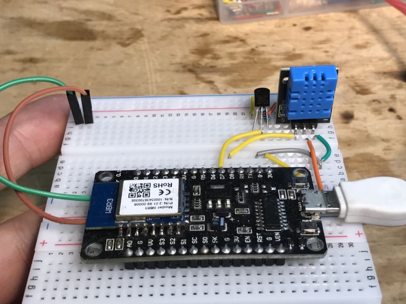 Electronic test setup on a breadboard with DS18B20 sensor and DHT11 module.