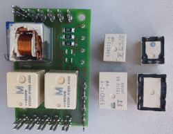 PCB with three relays and parts of two relay housings placed next to it on a tabletop