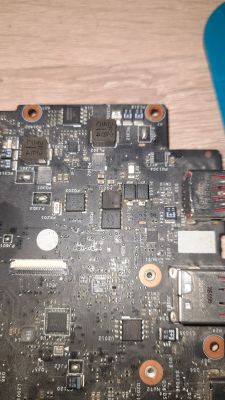 Zbliżenie na płytę główną laptopa z uszkodzonym układem scalonym.