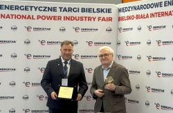 Dwaj mężczyźni z nagrodami na tle ścianki targów ENERGETAB 2025