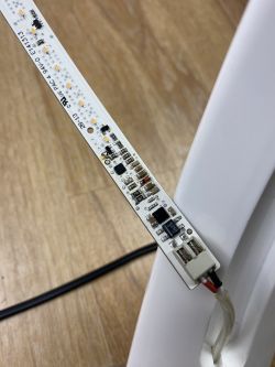 Zbliżenie na płytkę drukowaną LED z elementami elektronicznymi i podłączonym przewodem.