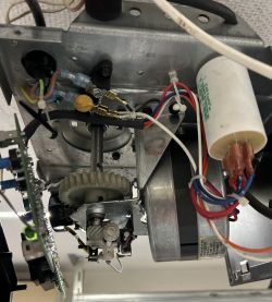 Wnętrze mechanizmu napędu bramy garażowej Chamberlain z widocznymi komponentami elektronicznymi i przewodami.